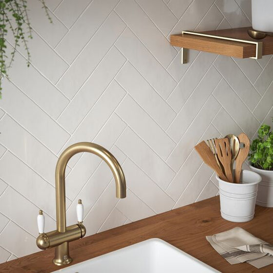 Kitchen featuring bespoke cream ceramic wall tiles arranged in a herringbone pattern