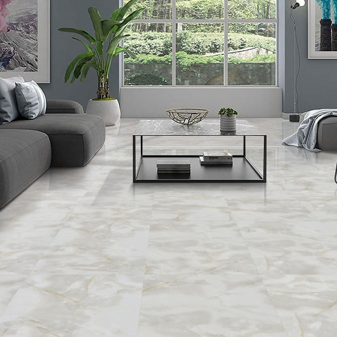 Living room featuring large 60x120 Onyx gold marble tile with polished finish and soft gold veining
